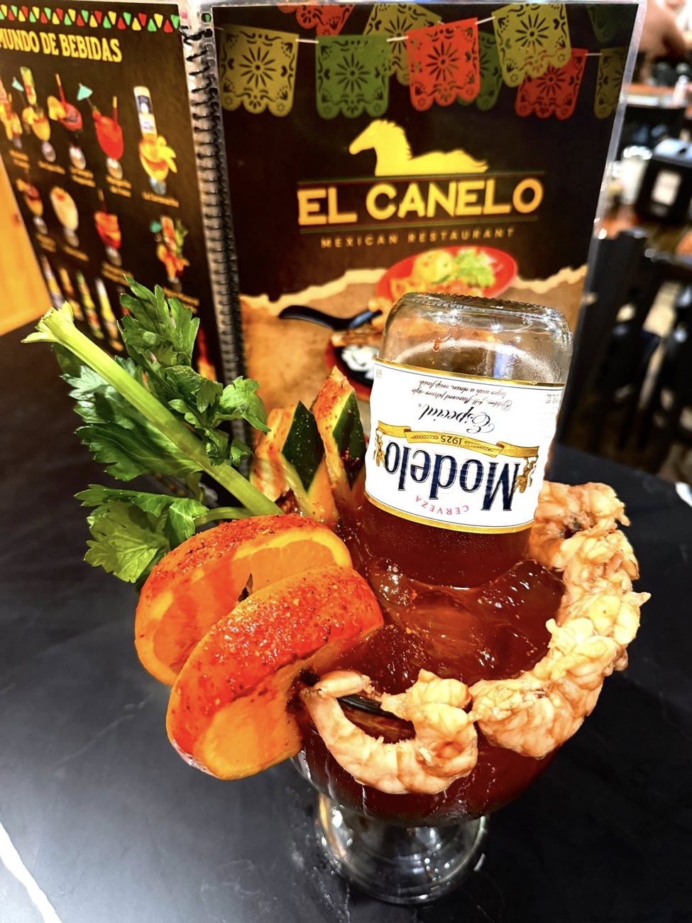 Michelada Modelo close-up — shrimp rim, cucumber, and chamoy