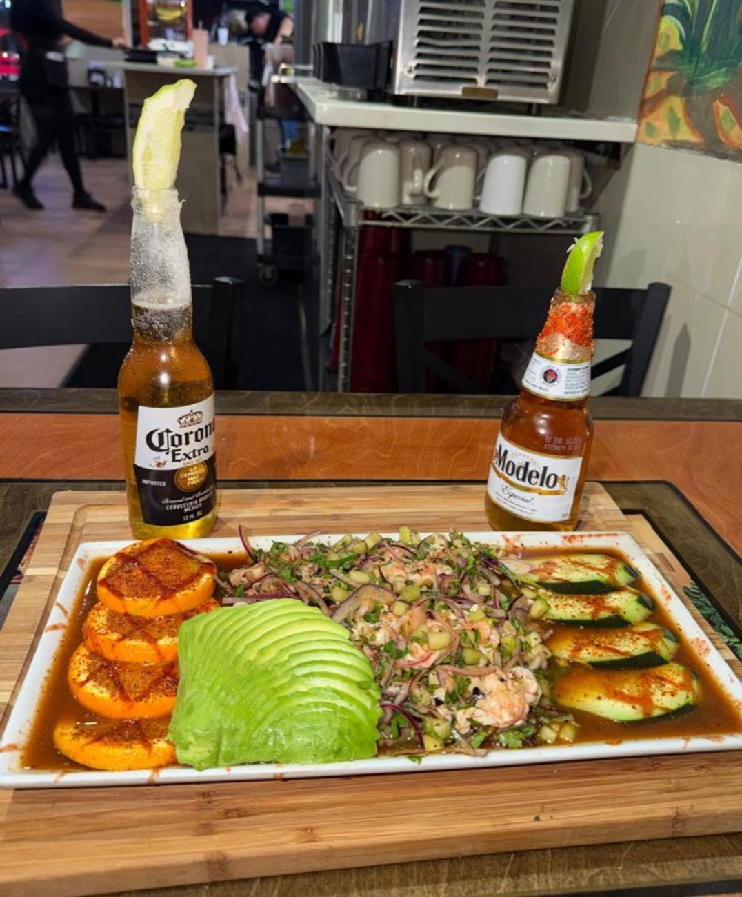 Aguachile de camarón with avocado slices and Corona micheladas